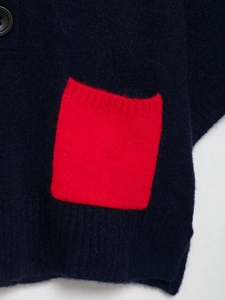 Detail of navy knit sweater with mohair texture, red pocket and black button accent
