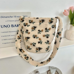 Close-up of soft beige plush bucket bag with vintage yellow floral pattern and matching strap