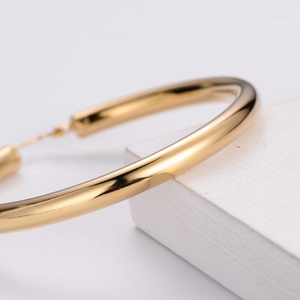 Polished 18k gold plated stainless steel hollow hoop earrings in a minimalist style