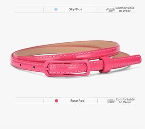 Macro detail of slim rose red glossy patent leather belt with matching metal pin buckle