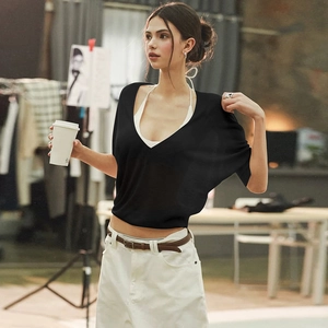 Close-up of a sheer black V-neck top with fine texture and stylish waist silhouette
