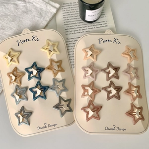 Glittering star-shaped hair clips for girls displayed on cardboards in various soft colors