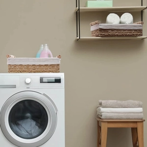 Detail of woven paper rope storage basket featuring wooden handles and linen lining