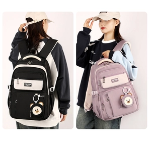 Dual view of black and purple backpacks showing multi-pocket design and bear pendant