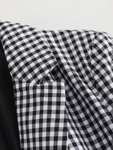 Close-up of black and white gingham blazer showing lapel stitching and fabric texture