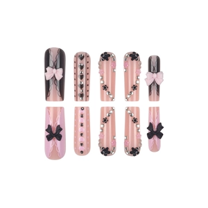 Pink and black bow press-on nails with rhinestones and heart patterns in long coffin shape