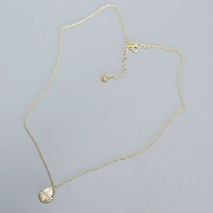 Detail showing the S925 hallmark on the gold heart charm of a teardrop pendant necklace