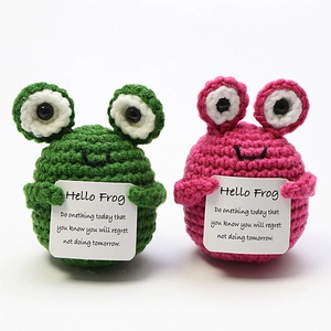 Detail of handmade crochet frog plushies in green and pink holding encouragement cards