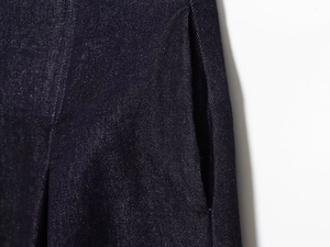 Close-up of deep blue denim fabric texture and pocket stitching on high waist wide leg jeans