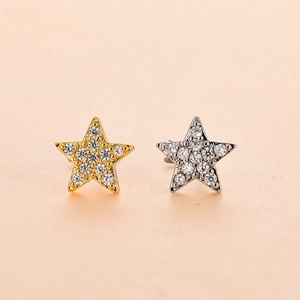 Macro detail of star-shaped nose studs with pave-set zircons in gold and silver finish
