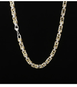Detail of 5mm two-tone stainless steel Cuban chain with lobster clasp on black background