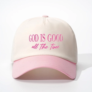 Close-up of God Is Good embroidery on a cream and pink two-tone baseball cap