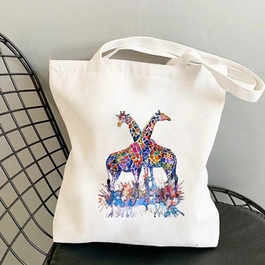 Detailed view of white canvas tote bag featuring a colorful watercolor giraffe print