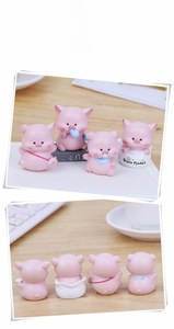Close-up of four creative pink resin pig figurines for car interior and desk decor