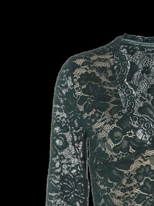 Detailopname van het donkergroene bloemenpatroon van kant op de schouder van het shirt