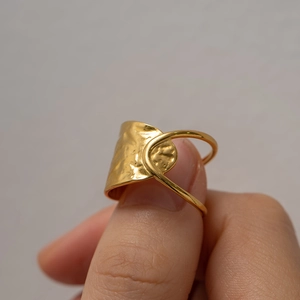 Detail of gold-plated stainless steel ring with a hammered texture and irregular design