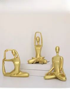 Detailed view of matte gold yoga figurines on decorative books for modern home decor
