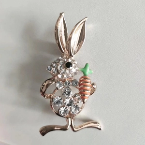 Close-up detail of golden rabbit brooch with sparkling rhinestones and carrot