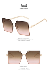 Detail view of large square sunglasses with beige chain link temples and gradient lenses
