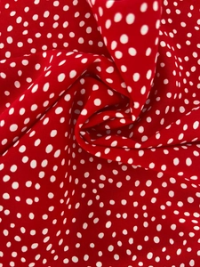 Macro shot of red polka dot fabric showing soft texture and lightweight drape detail
