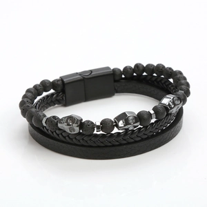Close-up of multilayer leather bracelet with volcanic stone beads and skull charms