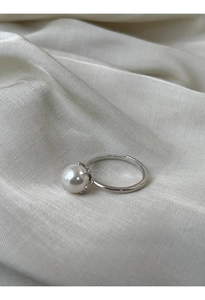 Macro del marchio argento S925 e della perla lucente su un anello minimalista