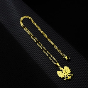 Polished gold double-headed eagle pendant necklace with O-chain on dark background