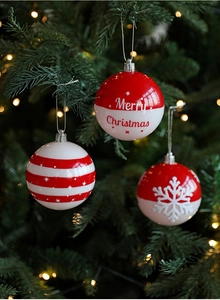 Gros plan de boules de Noël rouges et blanches avec motifs de neige et d'étoiles