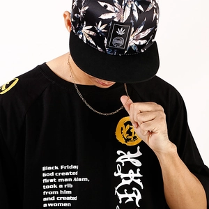 Close-up of golden stainless steel curb chain necklace worn by model on black shirt