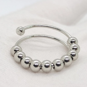 Macro detail of adjustable stainless steel anti-anxiety ring with 10 rotating beads
