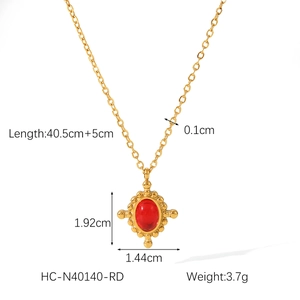 Detail view of gold titanium cross necklace with oval red gemstone and size measurements