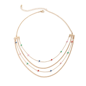 Close-up of multilayered gold necklace featuring vibrant colorful beads and lobster clasp