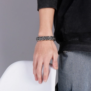 Detail of vintage gothic skull and cross bracelet on a male model's wrist