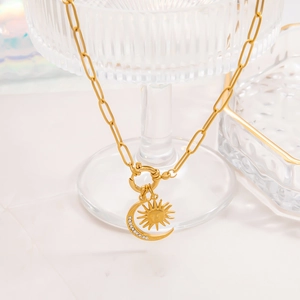 Gold stainless steel paperclip necklace featuring a rhinestone moon and sun pendant