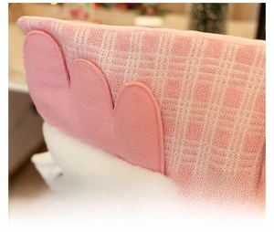 Macro detail of pink knitted fabric texture and soft felt trim on Christmas chair cover