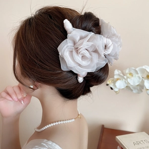 Pince à cheveux fleur en maille ivoire élégante sur une coiffure avec un décor raffiné