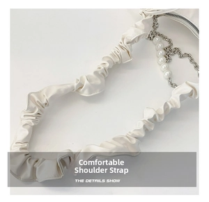 Detail of wide pleated shoulder strap with white pearl and silver metal chain accents