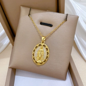 Close-up of gold oval Virgin Mary pendant with sparkling crystals on a fine chain