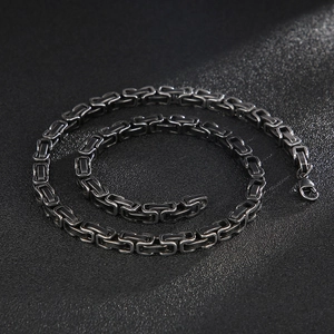 Macro view of gunmetal grey stainless steel Byzantine chain with square weave and lobster clasp