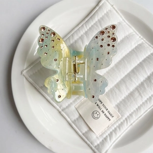 Detailed view of butterfly hair claw with gradient resin and sparkling rhinestones