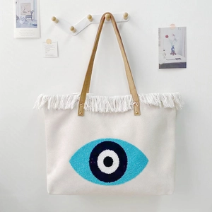 Bohemian canvas tote bag with evil eye embroidery and decorative white fringe trim