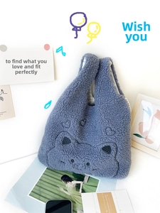 Close-up of blue fleece tote bag featuring cute cartoon embroidery and soft texture