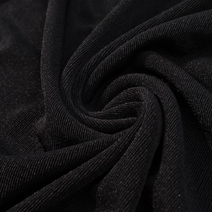 Gros plan sur un tissu noir scintillant avec paillettes fines et texture drapée