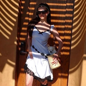 Scatto street style di un mini abito bianco con pizzo nero e borsa intrecciata dettaglio