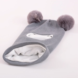 Detail of grey knitted baby balaclava with dual faux fur pom-poms and thick fleece lining