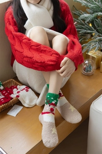 Close-up of thick coral fleece Christmas socks featuring cute 3D cartoon reindeer patterns