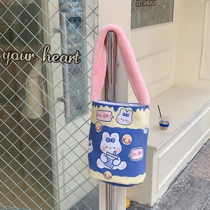 Dettaglio della borsa a secchiello in tela con coniglio cartoon e manico in peluche rosa