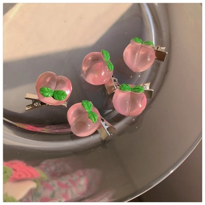 Close-up of pink peach hair clips with green leaves set of five in a glass tray