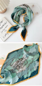 Detailed view of pleated silk scarf with floral patterns and artistic table styling