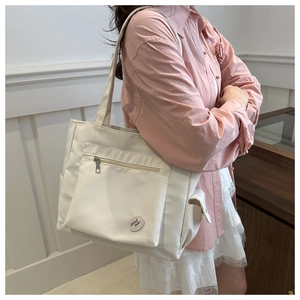 Minimalist white nylon tote bag with Good Luck text shown in a lifestyle setting